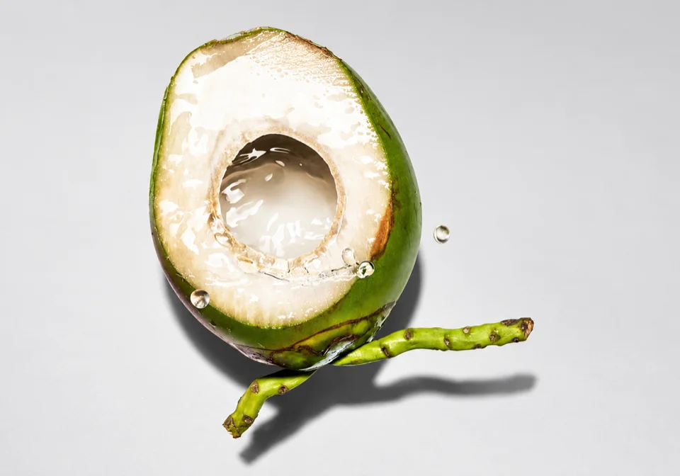 Halved green coconut with coconut water inside